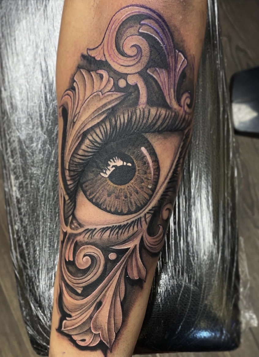 Realistic eye tattoo with ornamental filigree detail Austin TX