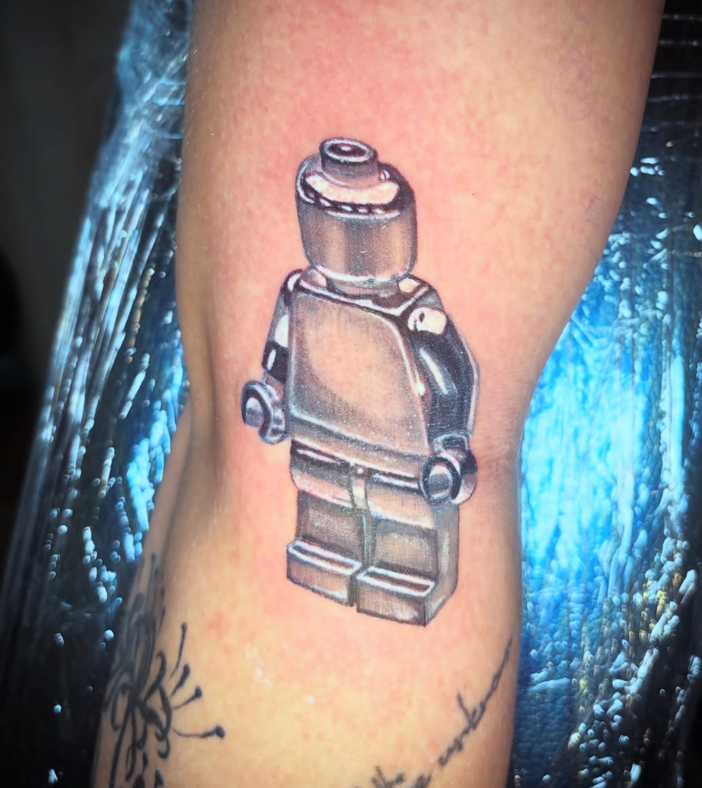 Realistic lego minifigure tattoo by Kiwi