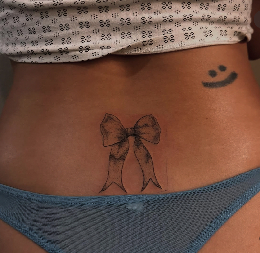 Fine line bow tattoo by Lauren