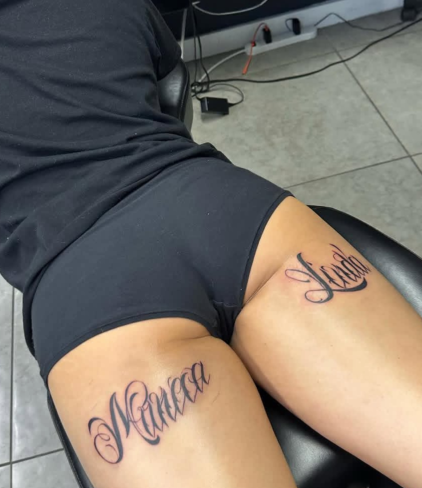 Script lettering thigh tattoos by Lauren