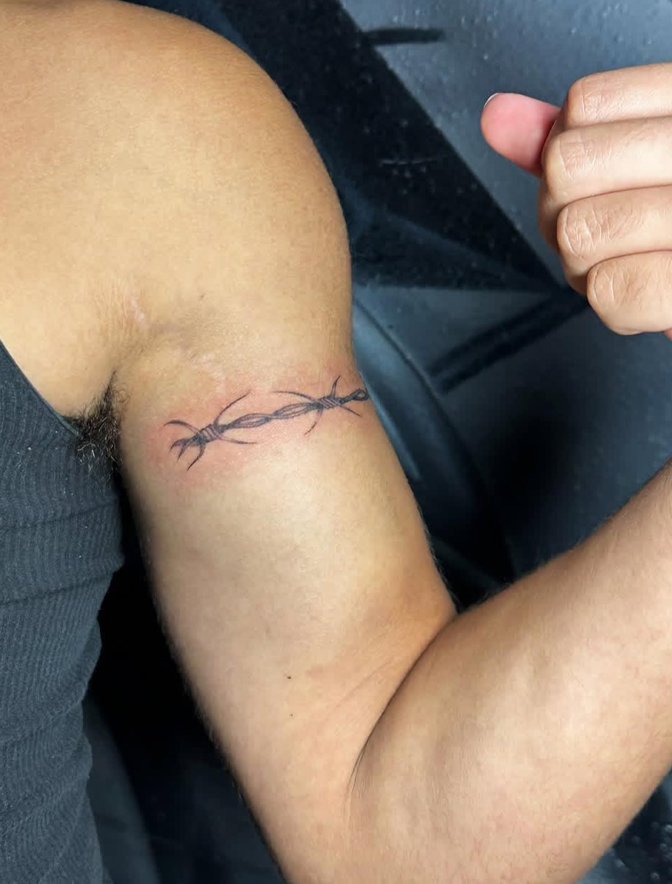 Barbed wire bicep tattoo by Lauren