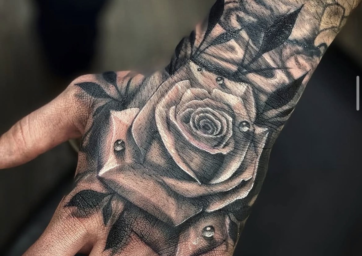 Black and grey rose hand tattoo by Stax